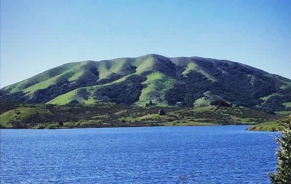 Black Mountain - home page@2x Sunny green mountain with blue water